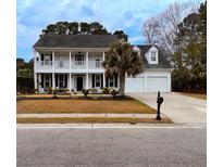 Charming two-story home with a double-decker front porch and a well-manicured lawn and an attached two-car garage at 2900 Colonnade Dr, Mount Pleasant, SC 29466