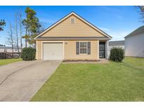 Charming single-story home with yellow siding, a garage, and a well-maintained lawn at 512 Resinwood Rd, Moncks Corner, SC 29461