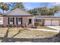 Charming single-story brick home featuring a well-manicured lawn, attached garage, and inviting entryway at 6 Allison Ct, Charleston, SC 29407