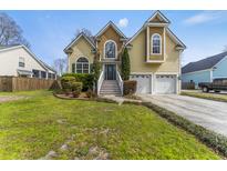 Charming two-story home featuring a well-manicured lawn, two-car garage, and inviting front entrance with mature trees at 644 Stoneboro Ct, Charleston, SC 29412