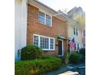 Charming brick townhouse with well-maintained landscaping, an American flag, and large windows at 7 Doughty St # C, Charleston, SC 29403