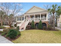 Inviting Lowcountry-style home featuring a spacious porch, landscaped yard, and charming architectural details at 8661 Refuge Point Cir, North Charleston, SC 29420