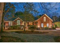 Charming brick home with manicured landscaping, inviting entrance, and warm exterior lighting at dusk at 1208 Wynnwood Ct, Mount Pleasant, SC 29464