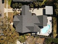 Aerial view of a home with a dark roof and a backyard pool surrounded by a patio and well-kept landscaping at 127 Beresford Creek St, Charleston, SC 29492