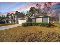 Charming home with a well-manicured lawn, garage, and beautiful sunset backdrop at 140 Moon Shadow Ln, Summerville, SC 29485
