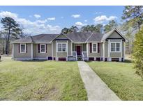 Inviting single-story home featuring a well-manicured lawn and a classic facade at 162 Wal Flo Ln, Moncks Corner, SC 29461