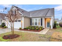 Charming home with a manicured front yard featuring mature landscaping, a two-car garage, and a welcoming entrance at 2012 Barn Swallow Rd, Summerville, SC 29483