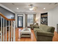Cozy living room with hardwood floors, ceiling fan, and bar with plentiful glassware storage at 204 Branch Creek Trl, Summerville, SC 29483
