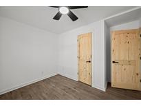 This bedroom features modern flooring, a ceiling fan, and beautiful wooden doors at 2124 Booker St, Charleston, SC 29405