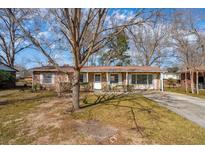 Charming brick home with a well-maintained front yard and mature trees providing shade at 28 Elmora Ave, Goose Creek, SC 29445