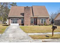 Charming brick home featuring a well-maintained lawn and a classic architectural design at 404 Terrier Rd, Goose Creek, SC 29445