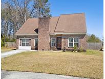 Charming brick home with a well-manicured lawn, brick chimney, and inviting front entrance at 404 Terrier Rd, Goose Creek, SC 29445