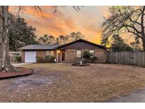Charming brick home with a well-manicured lawn, fountain, and a warm, inviting sunset backdrop at 7753 Linsley Dr, North Charleston, SC 29418