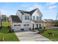 Charming two-story home with white siding, black accents, two-car garage, and well-manicured front lawn at 1022 Drakeford St # 10P, Saint George, SC 29477