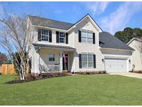 Charming two-story home with vinyl siding, a well-manicured lawn, and an attached two car garage at 107 Hainsworth Dr, North Charleston, SC 29418
