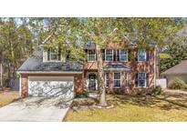 Charming two-story brick home with attached garage and lush front yard landscaping at 1104 Old Course Ln, Mount Pleasant, SC 29466