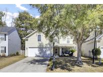 Charming two-story home featuring a well-manicured lawn and a large shade tree overhanging the front yard at 126 Moon Shadow Ln, Summerville, SC 29485