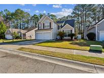 Charming two-story home featuring a manicured lawn, two-car garage, and inviting curb appeal at 1452 Water Edge Dr, Charleston, SC 29492