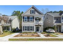 Charming two-story home with grey siding, black shutters, and a welcoming front porch, perfect for Southern comfort at 1764 Towne St, Johns Island, SC 29455