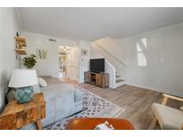 Comfortable living room with neutral paint, wood-look floors, area rug, and staircase access to the next level at 1836 Mepkin Rd # D4, Charleston, SC 29407