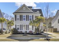 Charming two-story home featuring neutral siding, dark shutters and a beautifully landscaped front yard with palm trees at 2202 Kemmerlin St, Johns Island, SC 29455