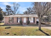 Charming single-story brick home featuring a white front door and manicured landscaping at 2236 Pinehurst Ave, Charleston, SC 29414
