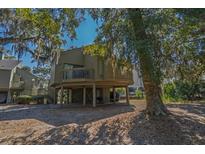 Charming raised beach house with wooden deck and shaded parking beneath the home at 601 Magnolia Ln, Edisto Island, SC 29438