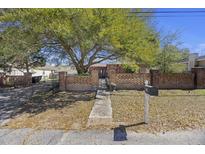 Charming home featuring a brick fence, mature shade tree, and inviting walkway at 680 Kent St, Mount Pleasant, SC 29464