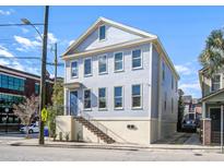 Charming two-story home with light blue siding, lots of windows and stairs to the front door at 757 King St, Charleston, SC 29403