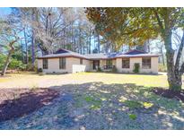 Charming single-story brick home with a well-maintained yard and mature trees, providing a serene and inviting curb appeal at 8340 Greenridge Rd, North Charleston, SC 29406