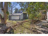 View of a two-story home featuring a two-car garage and a modern architectural style with lots of shady trees at 9 Stallion Ct, Charleston, SC 29407