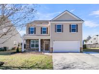 Charming two-story home featuring stone accents, neutral siding, and a well-manicured front lawn under a clear blue sky at 105 Endicott Ct, Summerville, SC 29486