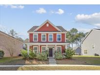 Charming two-story home with a well-manicured lawn and beautiful landscaping enhancing its curb appeal at 1151 Updyke Dr, Johns Island, SC 29455