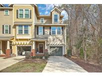 Two-story townhome with yellow and tan siding, attached garages, and a well-maintained lawn at 1204 Dingle Rd, Mount Pleasant, SC 29466