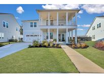 Charming two-story home with landscaped yard, covered porch, and attached garage at 136 Medford St, Summerville, SC 29486