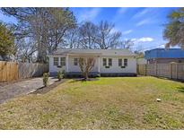 Charming single-story home featuring a well-maintained lawn and inviting curb appeal on a sunny day at 1605 Evergreen St, Charleston, SC 29407