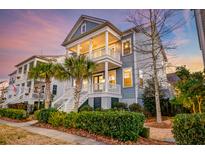 Charming two-story home with double porches, palm trees, manicured landscaping, and inviting curb appeal at 1625 Oak Leaf St, Daniel Island, SC 29492