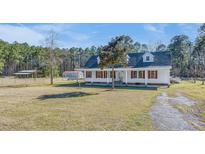 Beautiful home with red shutters, mature trees, and a spacious yard for outdoor activities at 1677 French Santee Rd, Jamestown, SC 29453