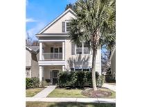 Charming two-story home featuring a welcoming front porch and beautifully landscaped front yard with mature palm tree at 1782 Towne St, Johns Island, SC 29455