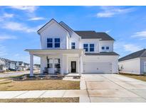 Charming two-story home with white siding, a covered front porch, and a two-car garage at 201 Garden Lily Lane, Summerville, SC 29485