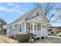 Charming grey home with white trim, a welcoming front porch, and well-maintained landscaping at 2097 Mt Pleasant St, Charleston, SC 29403