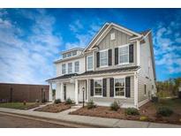 Charming two-story home with black shutters, landscaped yard, and a bright blue sky at 252 Abercom Place Dr, Moncks Corner, SC 29461