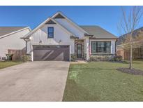 Charming single-Gathering home featuring a well-manicured lawn and attached two-car garage at 311 Citation Way, Moncks Corner, SC 29461