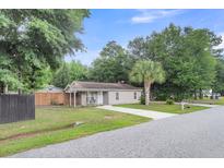 Charming single-story home with lush lawn, long driveway, and a classic, quaint curb appeal at 3316 Island Estates Dr, Johns Island, SC 29455