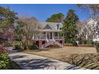 Charming two-story home featuring a welcoming front porch, brick foundation, and beautifully landscaped yard at 3448 Henrietta Hartford Rd, Mount Pleasant, SC 29466