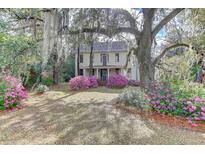 Charming two-story home featuring beautiful landscaping and mature trees draped with Spanish moss at 408 N Parler Ave, Saint George, SC 29477