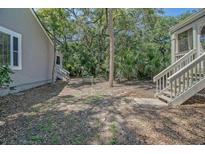 Relaxing backyard with lush greenery featuring a central tree and stairway to the right at 433 Double Eagle Trace, Seabrook Island, SC 29455
