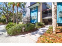 Stylish condo with lush landscaping, teal siding, and easy access to unit via path and stairs at 4901 Green Dolphin Way, Kiawah Island, SC 29455