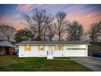Charming single-story home with a white brick exterior, attached garage, and well-maintained lawn at 792 Cartwright Dr, Charleston, SC 29414