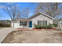 Charming single-story home featuring light gray siding, black shutters, and a vibrant blue front door at 106 Equestrian Ct, Summerville, SC 29486